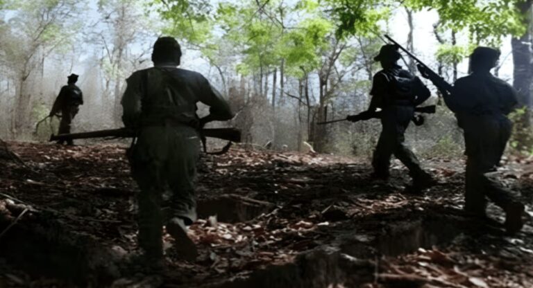 Naxalites walking through a forested area with weapons.